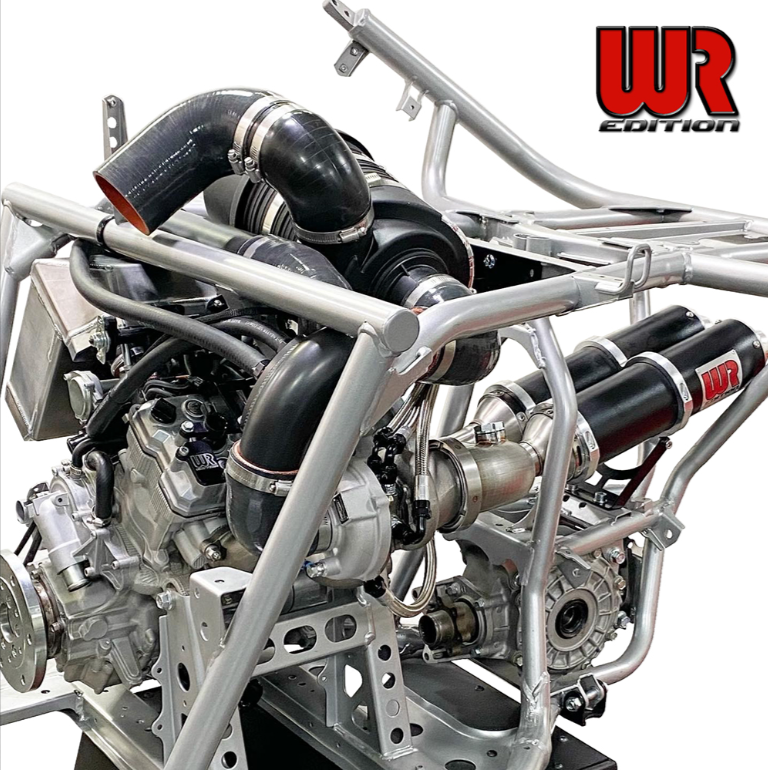 A high-performance engine setup with a silver tubular frame, black silicone intake hoses, a silver turbocharger, and red-and-black WR Edition exhaust stacks, shown on a white background with the WR EDITION logo in the top right.